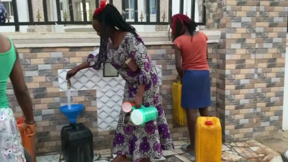 Filling containers with clean water at a Give Water Give Life tap.