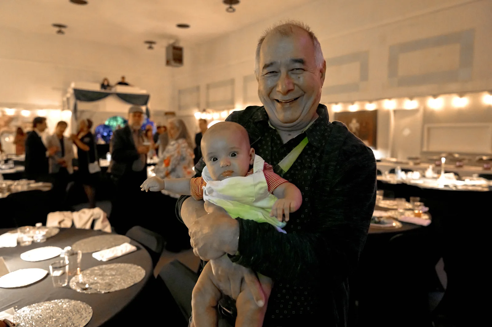 A Gala guest holding a baby during the evening.