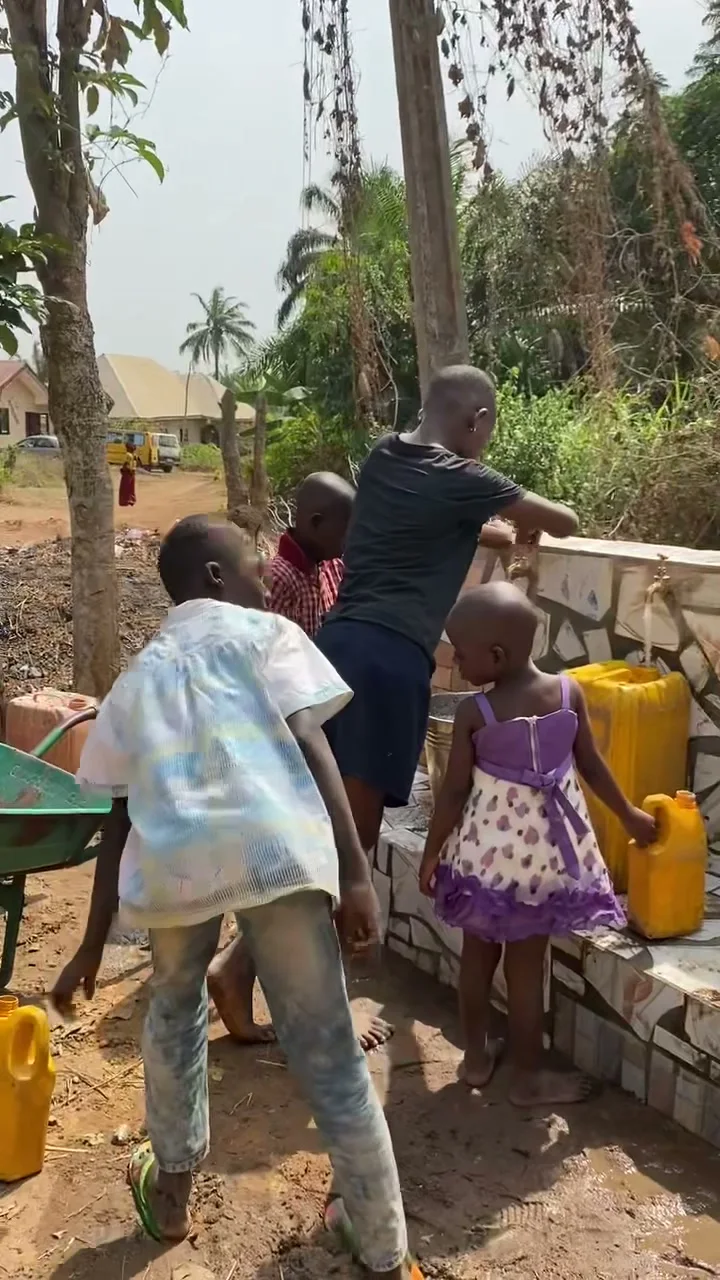 Children standing near a completed Give Water Give Life water system.